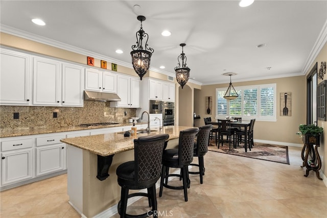 kitchen featuring sink, stainless steel gas stovetop, a kitchen island with sink, and white cabinets