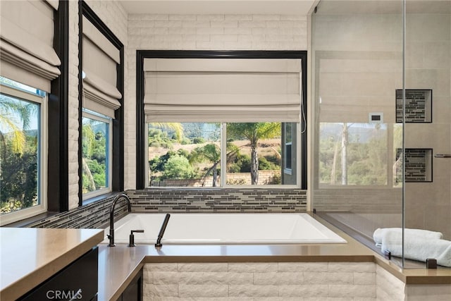 bathroom with vanity and tiled bath