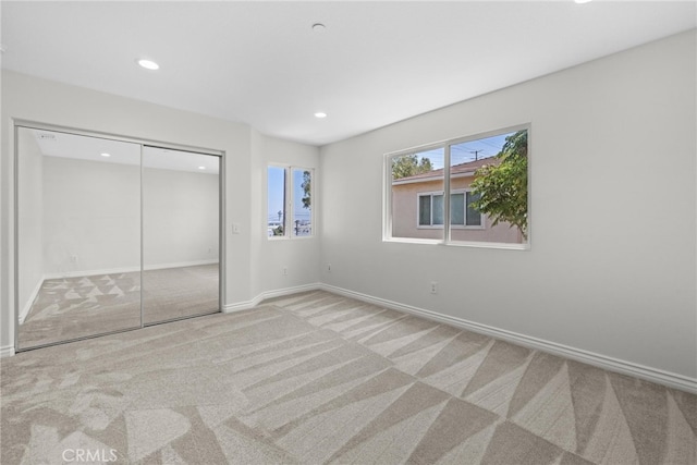 unfurnished bedroom with a closet and light carpet