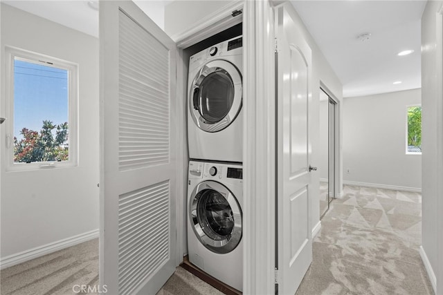 laundry area with light carpet and stacked washer and dryer