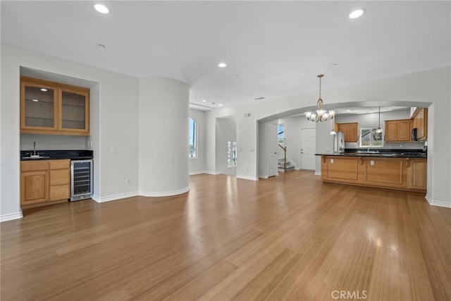 328 E Imperial Ave Unit 1, El Segundo, CA 90245 - unfurnished living room featuring beverage cooler, bar with sink, arched walkways, light wood-style floors, and recessed lighting