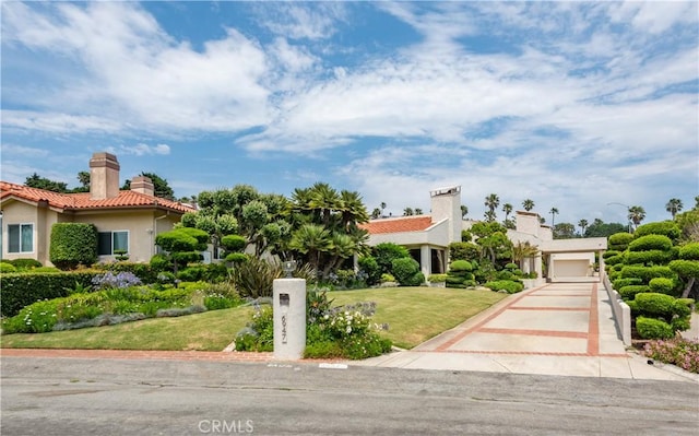 mediterranean / spanish house with a garage and a front yard