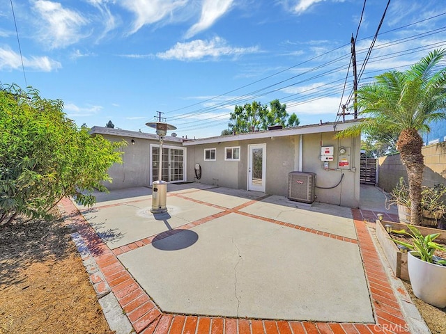 back of house with fence, a patio, and stucco siding