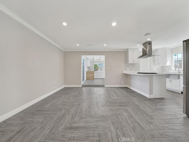 unfurnished living room with ornamental molding, recessed lighting, a healthy amount of sunlight, and baseboards