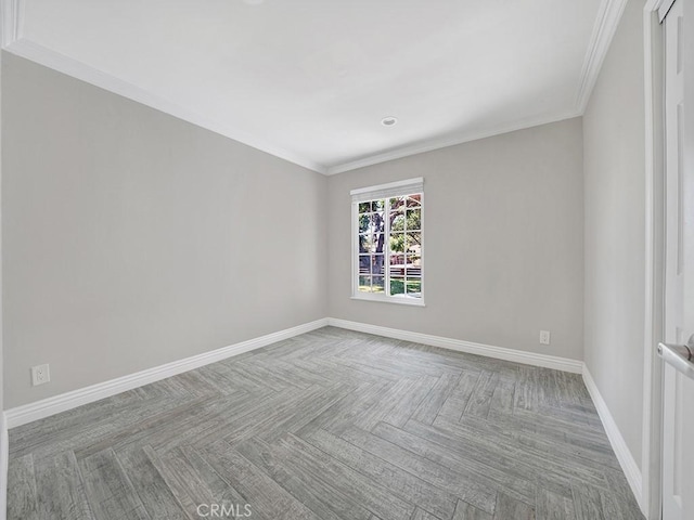 spare room with ornamental molding and baseboards