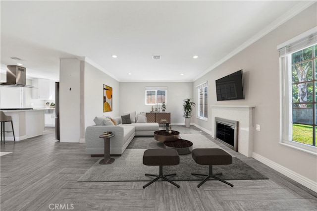 living room featuring crown molding, parquet floors, and a healthy amount of sunlight