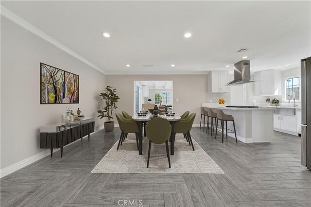 dining space with parquet flooring and ornamental molding