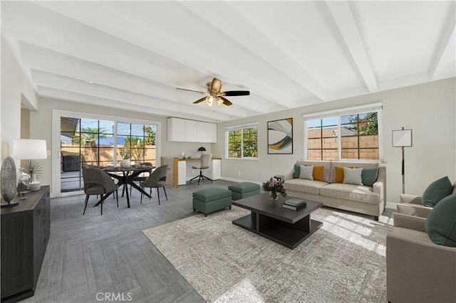 living room with beam ceiling, ceiling fan, and baseboards