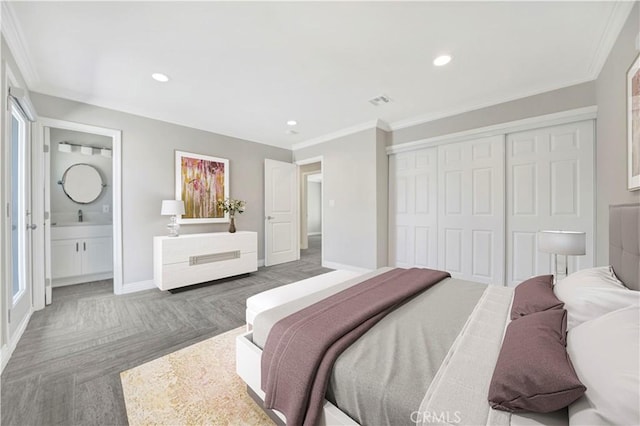 bedroom featuring crown molding, a closet, a sink, and baseboards