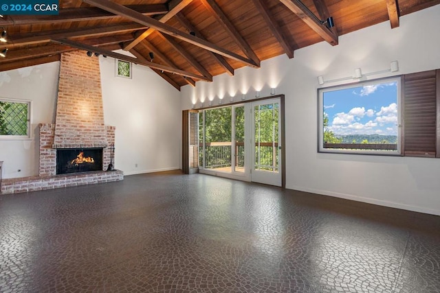 unfurnished living room featuring plenty of natural light, beamed ceiling, wood ceiling, and a brick fireplace