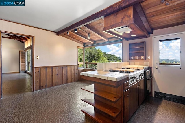 kitchen with custom range hood, vaulted ceiling with beams, a healthy amount of sunlight, and wood ceiling