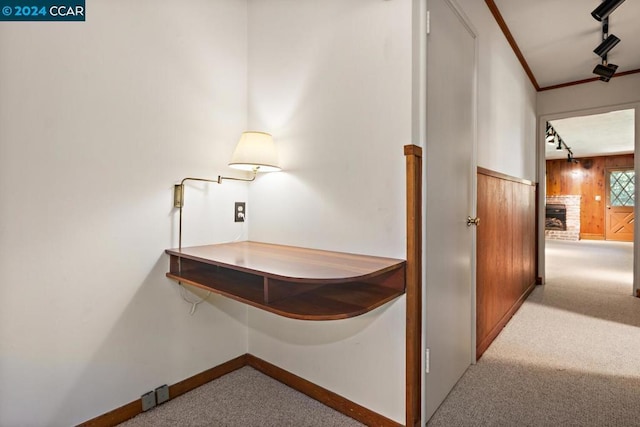 hallway featuring light carpet, crown molding, and wooden walls