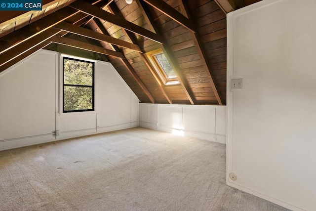 bonus room with wooden ceiling, vaulted ceiling with skylight, and light colored carpet