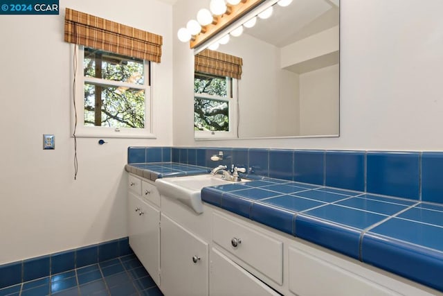 bathroom with tile patterned floors, vanity, and backsplash