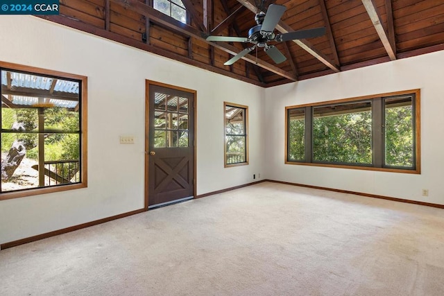 unfurnished room with beamed ceiling, light carpet, and a wealth of natural light