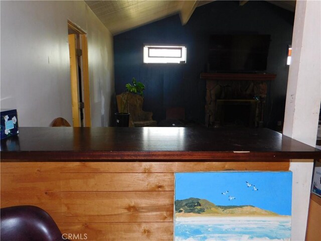 bar featuring lofted ceiling with beams and a fireplace