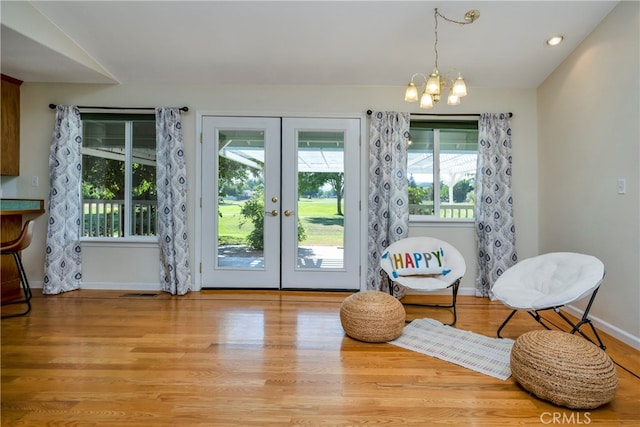 sitting room featuring wood-type flooring, a chandelier, and a healthy amount of sunlight