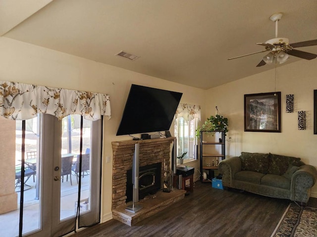 living room featuring hardwood / wood-style floors, a wood stove, french doors, vaulted ceiling, and ceiling fan