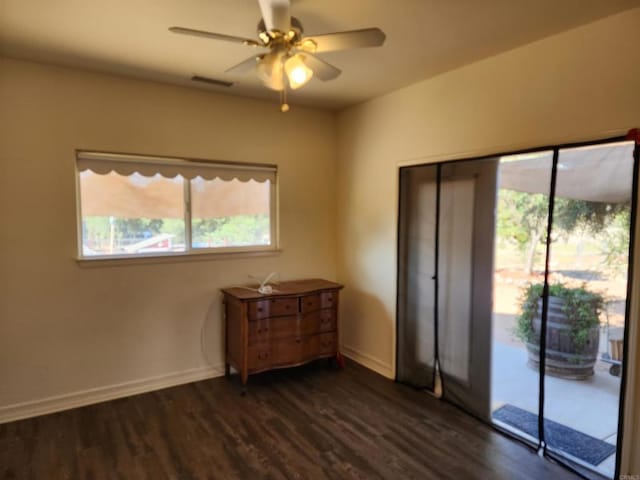 unfurnished bedroom featuring access to exterior, dark hardwood / wood-style floors, and ceiling fan