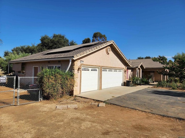 view of front of property featuring a garage and solar panels