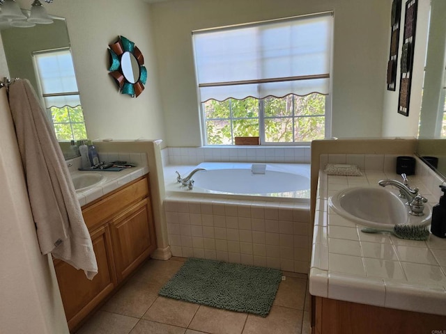 bathroom featuring tile patterned floors, vanity, a wealth of natural light, and tiled bath