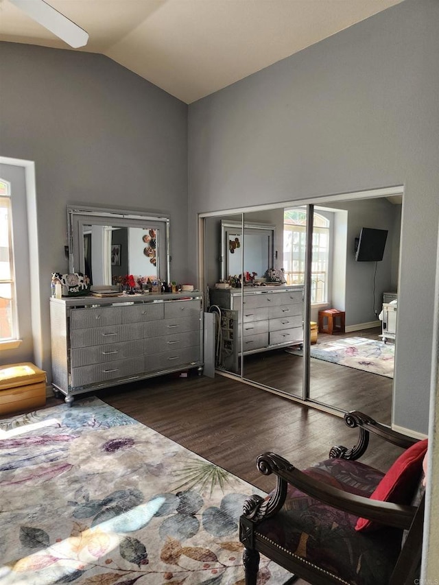 bedroom with ceiling fan, dark hardwood / wood-style flooring, and high vaulted ceiling