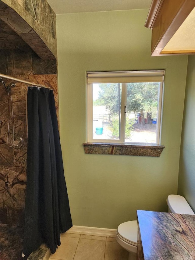 bathroom featuring tile patterned flooring, vanity, toilet, and curtained shower