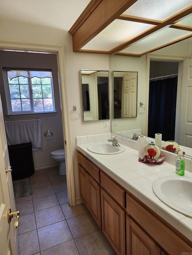 bathroom with tile patterned floors, vanity, and toilet