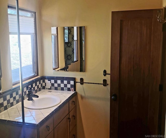 bathroom featuring vanity and backsplash