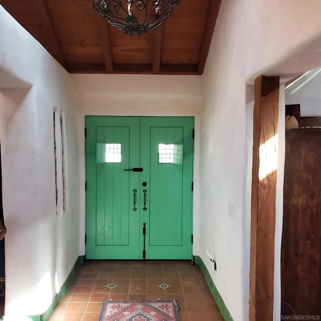 entryway featuring beam ceiling, wooden ceiling, and tile patterned floors