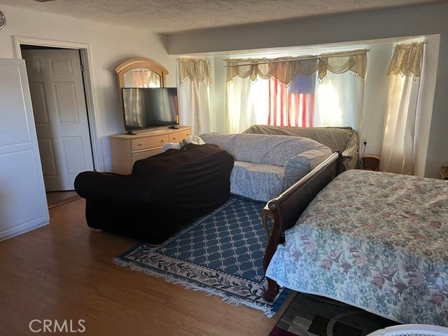 bedroom featuring hardwood / wood-style floors and a textured ceiling