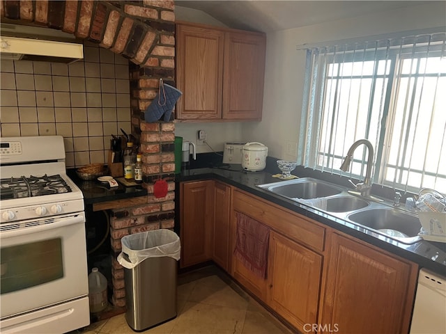 kitchen featuring sink, light tile patterned floors, backsplash, and white appliances