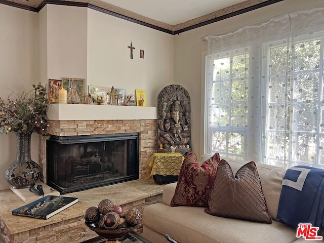 living room featuring crown molding and a fireplace