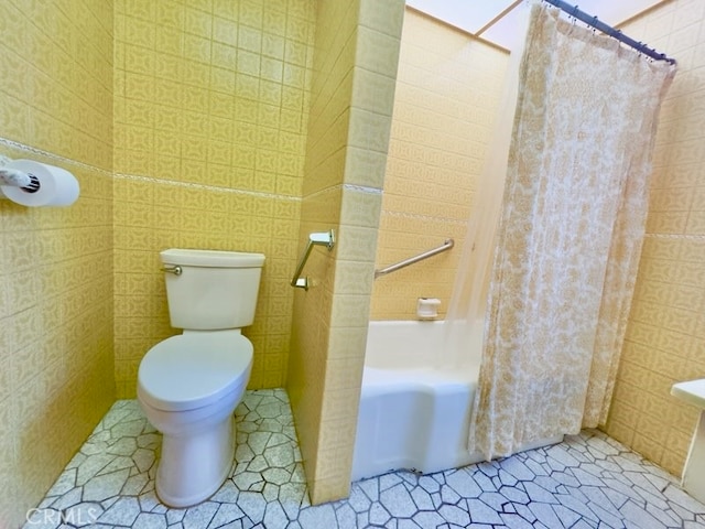 bathroom with toilet, shower / bath combination with curtain, tile patterned floors, and tile walls