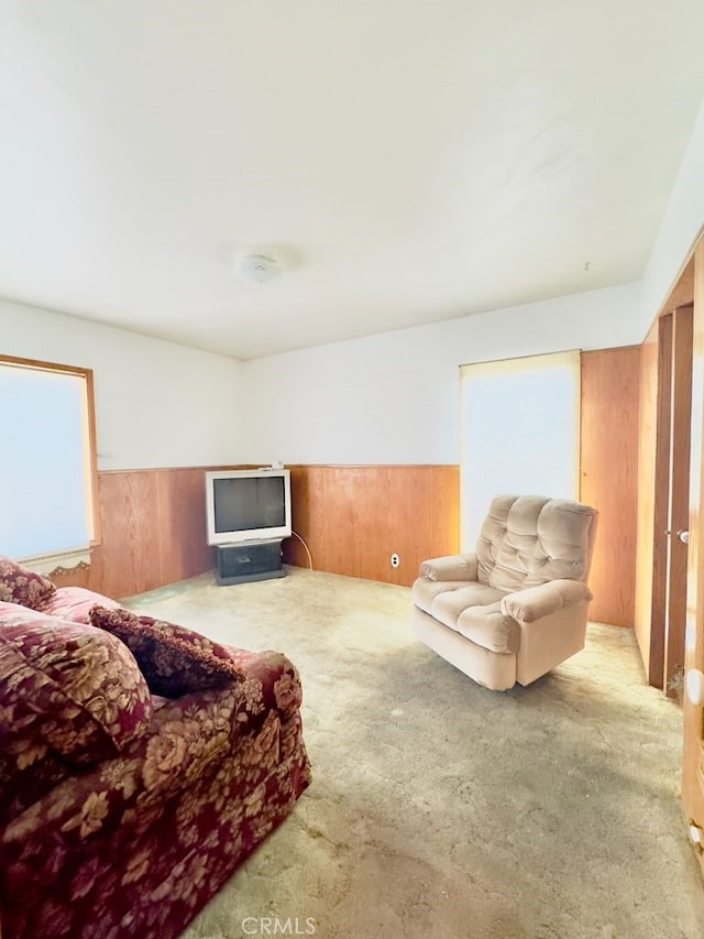 living room with wooden walls and light carpet