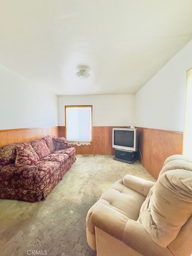 living room with wooden walls and light colored carpet