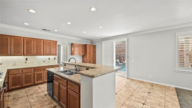 kitchen featuring dishwasher, sink, an island with sink, and a wealth of natural light