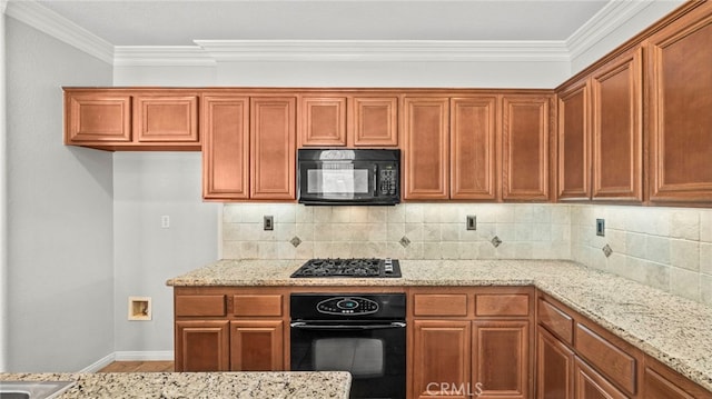 kitchen featuring black appliances, crown molding, decorative backsplash, and light stone counters