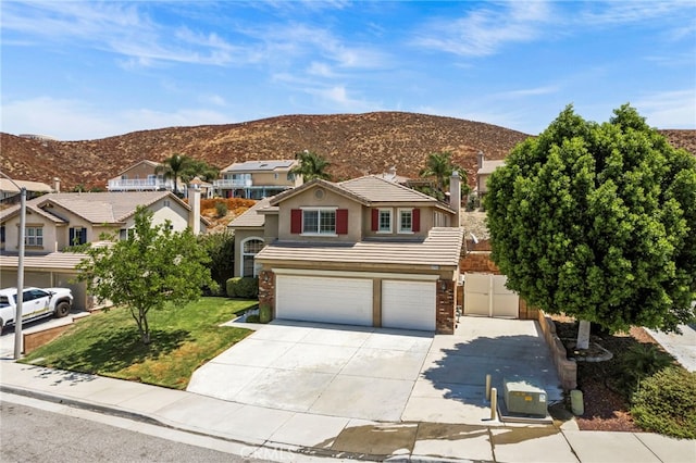 view of front facade with a mountain view, a front lawn, and a garage