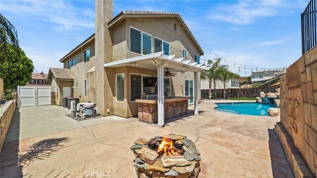 back of house with a patio, a pergola, a fenced in pool, and a fire pit