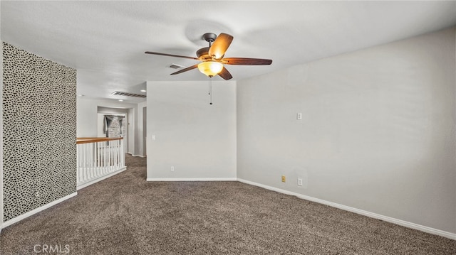 unfurnished room with dark colored carpet and ceiling fan