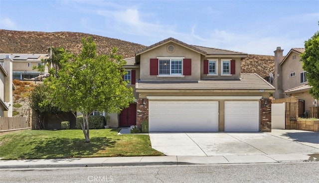 view of front facade with an attached garage, a tile roof, fence, driveway, and stucco siding