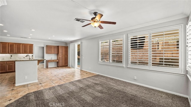 interior space with ceiling fan, sink, ornamental molding, light colored carpet, and decorative backsplash