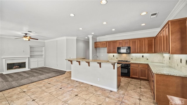 kitchen featuring black appliances, light stone countertops, ceiling fan, and tasteful backsplash