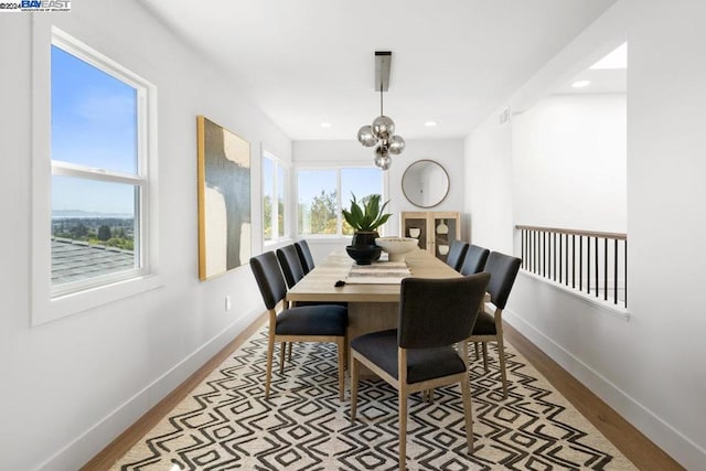 dining space featuring light hardwood / wood-style floors, a chandelier, and a wealth of natural light