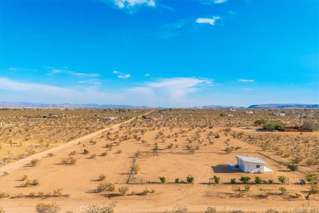 drone / aerial view featuring view of desert, a mountain view, and a rural view