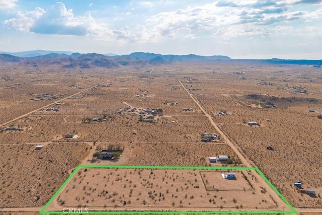 drone / aerial view featuring a mountain view, a rural view, and view of desert