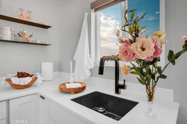 interior space featuring sink and white cabinetry