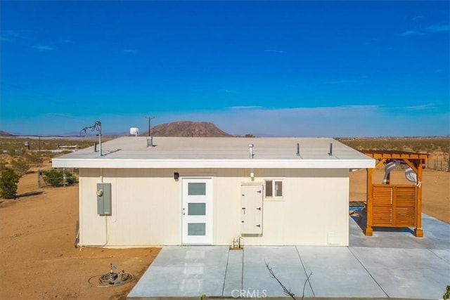 back of property with a patio and a mountain view