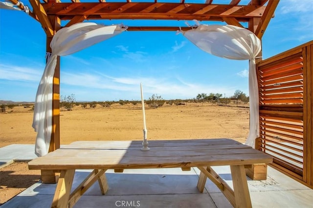 view of patio featuring a pergola and a rural view